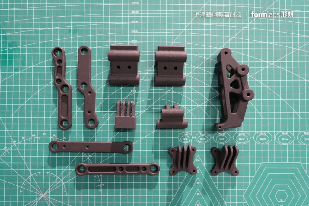 Функціональні деталі з нейлону PA12, надруковані на Formlabs Fuse 1+ 30W: кронштейни, шарніри та монтажні елементи. Зображення: Formlabs / Shanghai Xichuang Education Technology.